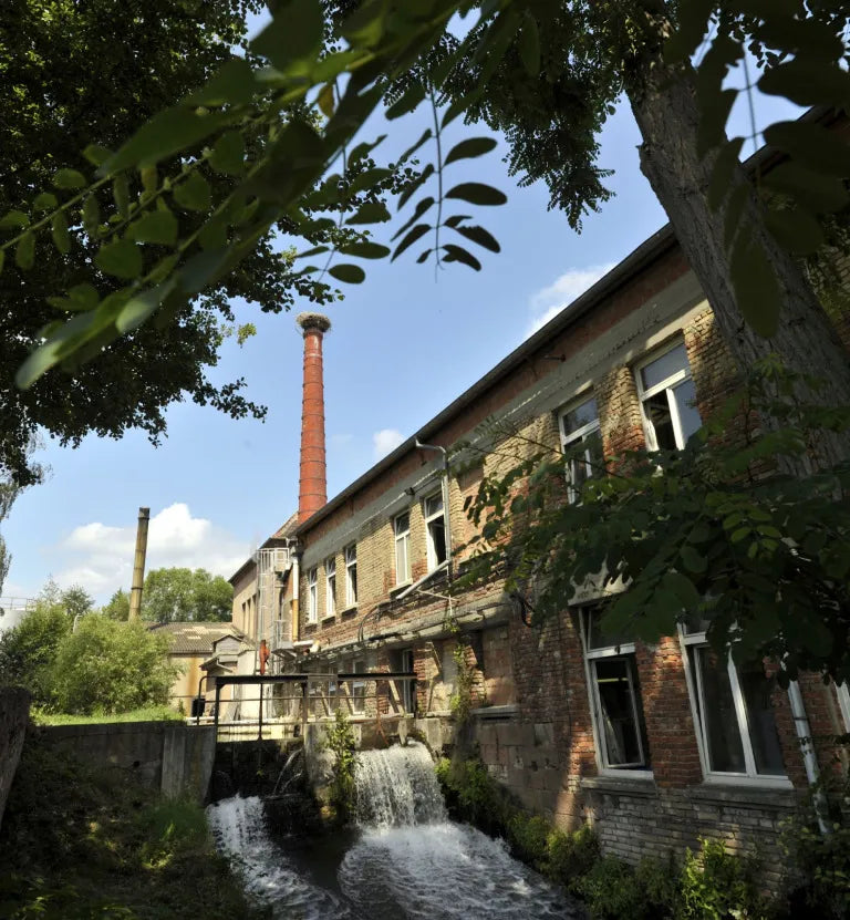 Tannerie Haas in France – historic leather tannery building with brick walls, chimneys, and a water stream used in traditional tanning processes.